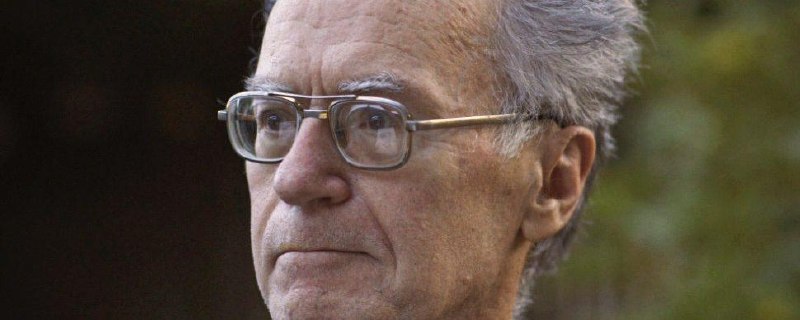 Close-up portrait of Ray Peat wearing glasses, looking to the side.